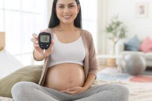 grávida mulher verificação sangue açúcar nível de usando digital glicose metro, saúde Cuidado, medicamento, diabetes, glicemia conceito foto