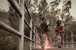 soldados dentro camuflar uniformes visando com seus rifles pronto para fogo durante militares Operação dentro a floresta , soldados Treinamento dentro uma militares Operação foto