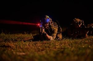 soldados dentro camuflar uniformes visando com seus rifles pronto para fogo durante militares Operação às noite, soldados Treinamento dentro uma militares Operação foto