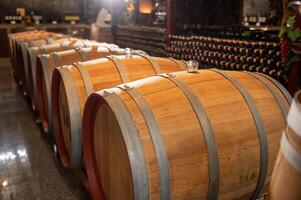 velho de madeira vinho barris empilhado dentro uma porão dentro ordem foto
