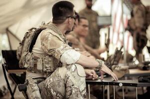 soldados dentro camuflar uniformes planejamento em Operação dentro a acampamento, soldados Treinamento dentro uma militares Operação foto