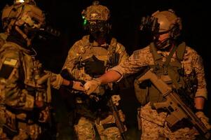 soldados dentro camuflar uniformes visando com seus rifles prontos para fogo durante militares Operação às noite soldados Treinamento dentro uma militares Operação foto