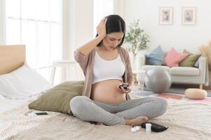 grávida mulher verificação sangue açúcar nível de usando digital glicose metro, saúde Cuidado, medicamento, diabetes, glicemia conceito foto