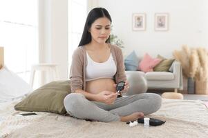 grávida mulher verificação sangue açúcar nível de usando digital glicose metro, saúde Cuidado, medicamento, diabetes, glicemia conceito foto