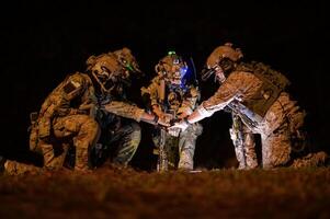 soldados dentro camuflar uniformes visando com seus rifles pronto para fogo durante militares Operação às noite, soldados Treinamento dentro uma militares Operação foto