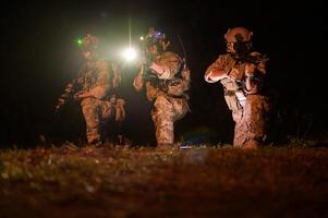 soldados dentro camuflar uniformes visando com seus rifles prontos para fogo durante militares Operação às noite soldados Treinamento dentro uma militares Operação foto