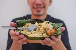 ásia homem segurando uma prato do arroz com frango e vegetal foto