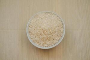 uma tigela do arroz em uma de madeira mesa foto