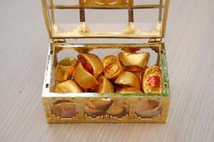 chinês ouro chocolates em de madeira mesa fundo, chinês doces foto