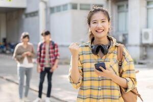 lindo aluna ásia mulher e amigo com surpresa anunciar final exame. sorrir menina feliz dentro Faculdade campus. retrato fêmea em internacional Ásia universidade. Educação, estudar, escola, feliz foto