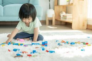 feliz ásia criança jogando e Aprendendo brinquedo blocos. crianças estão muito feliz e animado às lar. criança ter uma ótimo Tempo jogando, Atividades, desenvolvimento, atenção déficit hiperatividade transtorno foto