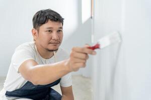 pintor homem, escova dentro mão para produtos para restaurar e pintura a parede, interior a construção local do uma casa, parede durante pintura, renovação, pintura, contratante, arquiteto, construção trabalhador foto