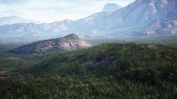 panorama com rolando verde Campos e majestoso montanhas dentro a distância foto