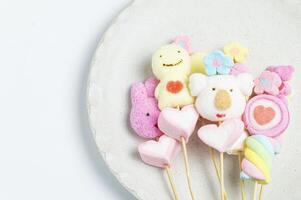 uma prato com marshmallows e doce em Gravetos foto