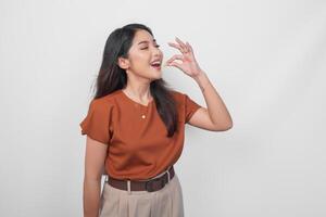 jovem ásia mulher dentro Castanho camisa segurando uma remédio comprimido com feliz sorrir expressão isolado de branco fundo. foto