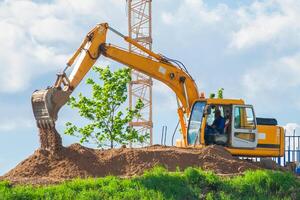 escavadora e torre guindaste em a construção local foto