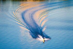 bicicleta aquática, embarcação cria ondas iluminado de a Sol foto
