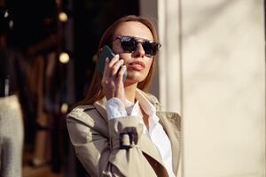 focado empresária dentro oculos de sol é falando telefone em cidade rua fundo foto