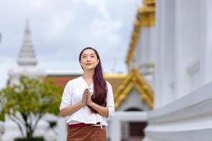 mulher asiática budista está fazendo meditação andando ao redor do templo para a paz e o conceito de prática religiosa tranquila foto