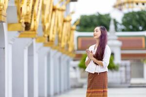 mulher asiática budista está fazendo meditação andando ao redor do templo para a paz e o conceito de prática religiosa tranquila foto