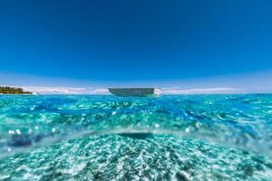 turquesa oceano com arenoso inferior dentro trópicos e pescaria barco foto