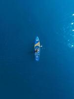 pode 20, 2022. dalaman, peru. mulher em ficar de pé acima remo borda às azul mar. mulher caminhando em sup borda dentro oceano. aéreo Visão foto