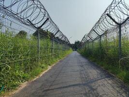 uma conectando estrada entre aldeias dividindo a Proibido entrada área às adi Soemarmo aeroporto, Surakarta foto