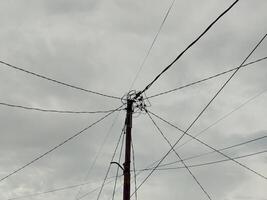 baixo ângulo Visão do elétrico cabos contra nublado céu foto