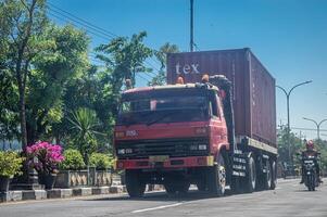 uma reboque caminhão carregando logística ou Remessa containers, Indonésia, 16 pode 2024. foto