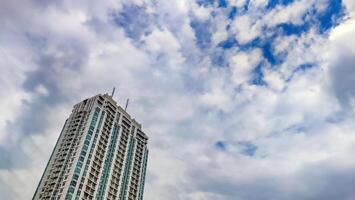 uma Alto subir construção apartamento com nublado céu cópia de espaço foto