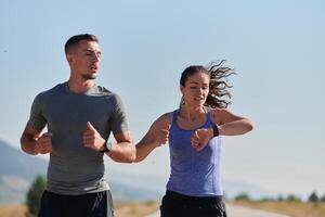 energizado de a beleza do natureza, uma casal poderes através seus manhã correr, seus corpos e espíritos revigorado. foto