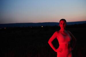 atleta greves uma pose dentro iluminado em vermelho período noturno brilho foto