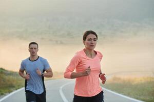 energizado de a beleza do natureza, uma casal poderes através seus manhã correr, seus corpos e espíritos revigorado. foto