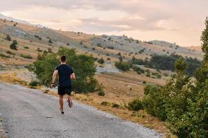 determinado atleta corrida através áspero montanha terreno às nascer do sol. foto