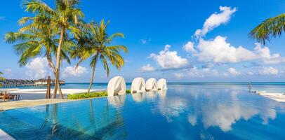 deslumbrante paisagem, natação piscina azul céu com nuvens. tropical recorrer hotel dentro Maldivas. fantástico relaxar e pacífico vibrações, cadeiras, espreguiçadeiras debaixo guarda-chuva e Palma folhas. luxo viagem período de férias foto