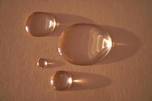 lindo volumétrico gotas do Cosmético produtos em uma bege fundo. foto