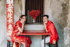 feliz jovem casal asiático em vestidos tradicionais chineses foto