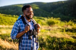 jovem homem goza caminhada dentro natureza. foto