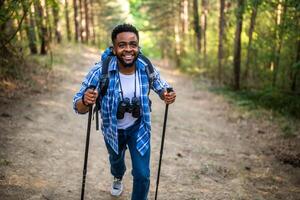 jovem homem goza caminhada dentro natureza. foto