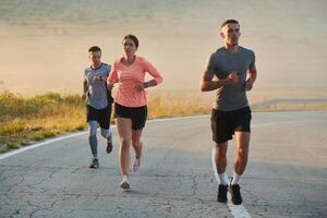 uma grupo do amigos, atletas, e corredores abraço a cedo manhã horas Como elas corre através a enevoado alvorecer, energizado de a Aumentar Sol e cercado de a tranquilo beleza do natureza foto