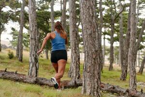 destemido mulher conquistando de madeira obstáculos dentro a perigoso floresta terreno. foto