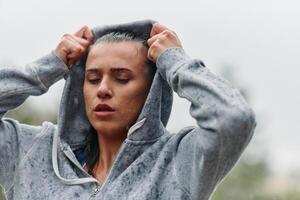 mulher em repouso dentro a chuva depois de intenso corre foto