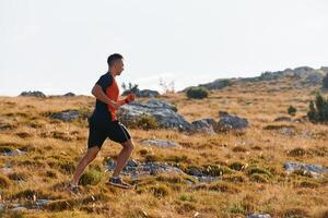 determinado atleta corrida através áspero montanha terreno às nascer do sol. foto