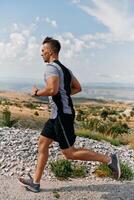 determinado atleta corrida através áspero montanha terreno às nascer do sol. foto