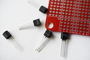 vermelho impresso o circuito borda e salgadinhos e rádio componentes. capacitores e transistores. foto