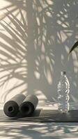 garrafa do água Próximo para dois enrolado acima ioga tapetes foto