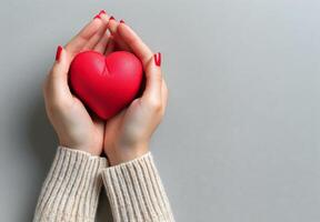 pessoa segurando vermelho coração dentro mãos foto