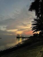 pôr do sol Tempo dentro Calcutá de praia e grande navio dentro água foto