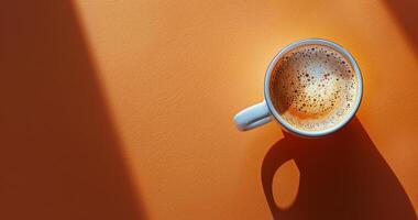 topo Visão do uma copo do café com canela granulados em a laranja fundo foto