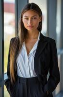 mulher com Castanho cabelo vestindo uma branco camisa e bege blazer dentro uma moderno escritório configuração foto